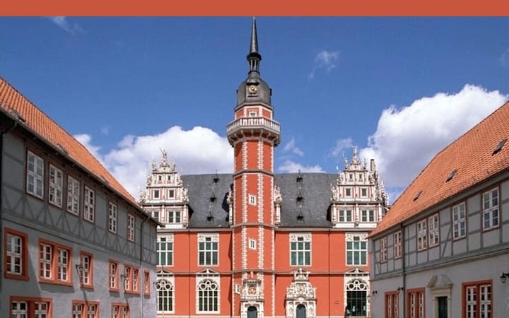 The Juleum in Helmstedt, a Renaissance university building with a tall tower, framed by half-timbered houses.